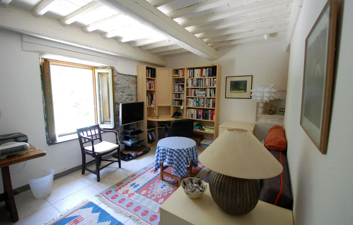Comfortable sitting room with bookshelves, desk and armchairs