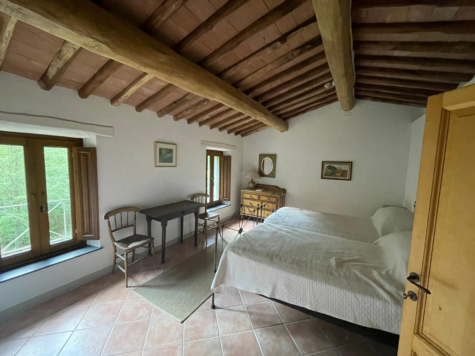 Double bedroom with exposed beams and views over the Tuscan hillside