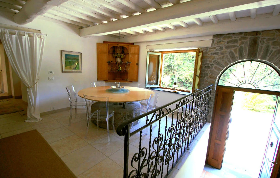 Upper dining and entrance area with round table and arched doorway