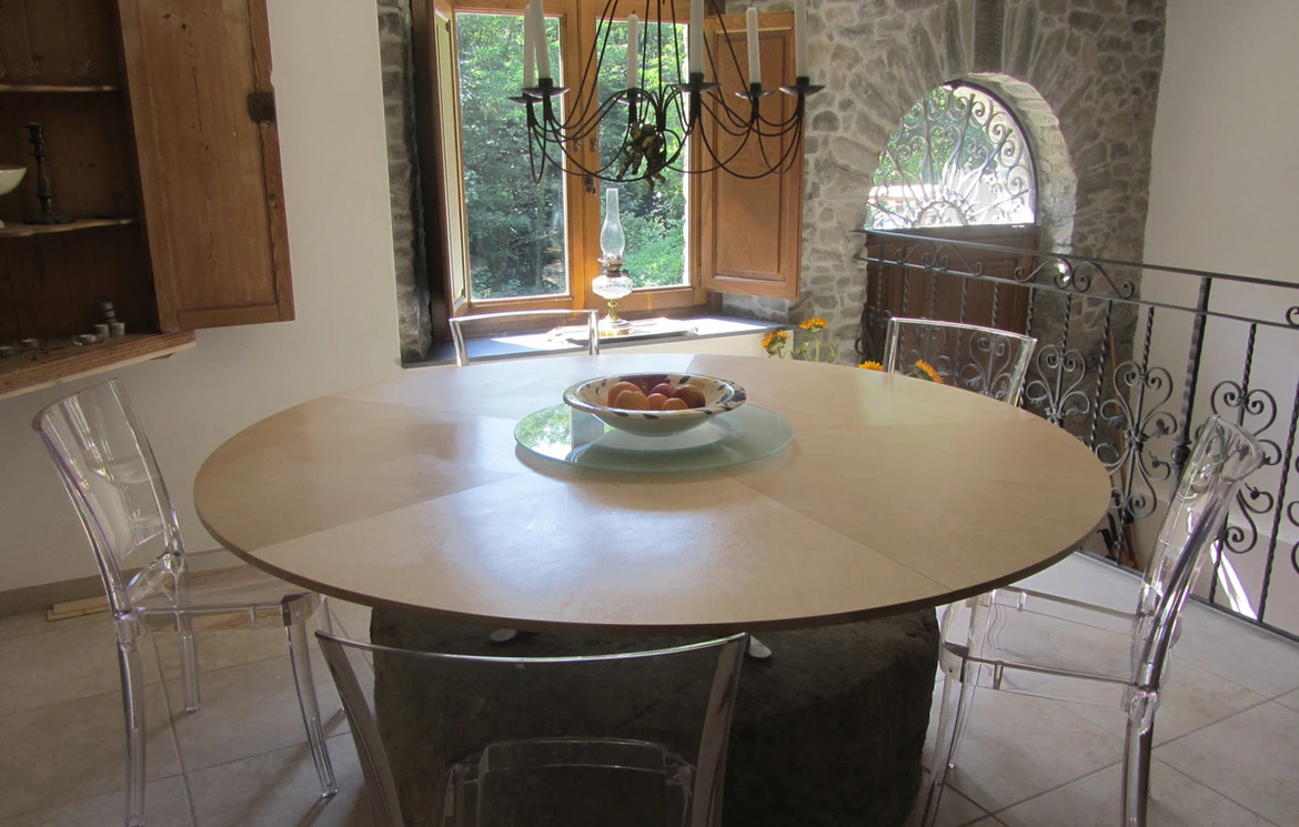 Round dining table in the millhouse dining room with stone details