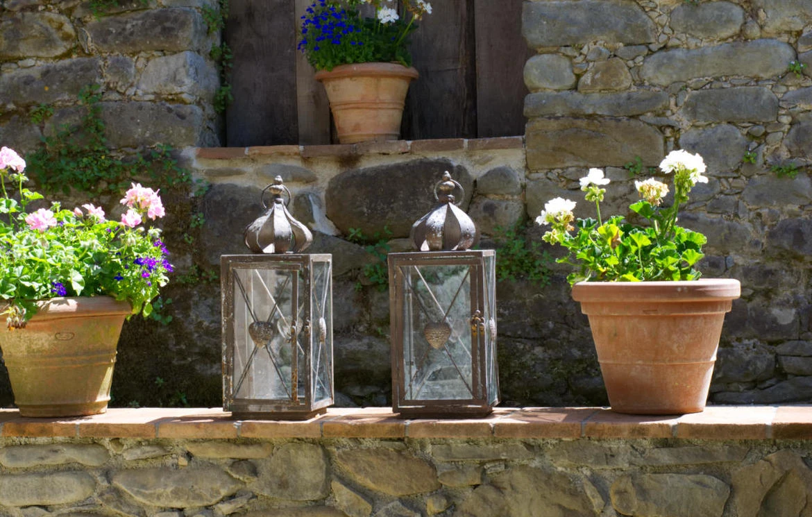 Potted flowers and metal lanterns on the stone exterior steps